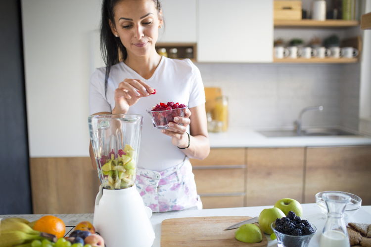 woman in white making a smootie